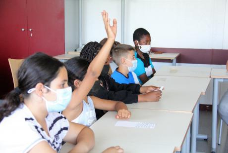 Photo prise dans le cadre du projet Projet philo-plastique. Nous voyons des élèves assis dans une salle de classe, avec leur enseignante. 