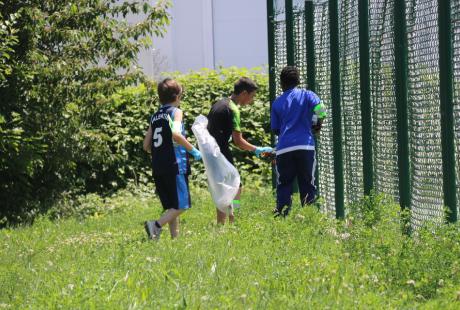 Photo prise dans le cadre de l'opération Ville propre.  Nous voyons des bénévoles, équipées de  gants, de pinces et de sacs, ramassant les déchets par terre.