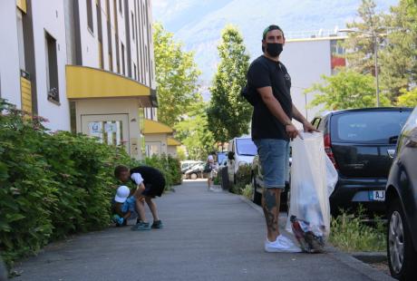 Photo prise dans le cadre de l'opération Ville propre.  Nous voyons des bénévoles, équipées de  gants, de pinces et de sacs, ramassant les déchets par terre.