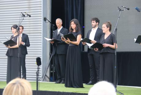 Photo de la présentation de saison la Rampe-La Ponatière pour la saison 2021-2022. Nous voyons Le chœur Spirito sur scène. Les chanteurs et chanteuses sont habillé-es en noir et blanc. Ils intérprètent un de leur morceau.