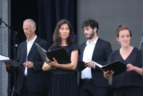 Photo de la présentation de saison la Rampe-La Ponatière pour la saison 2021-2022. Nous voyons Le chœur Spirito sur scène. Les chanteurs et chanteuses sont habillé-es en noir et blanc. Ils intérprètent un de leur morceau.