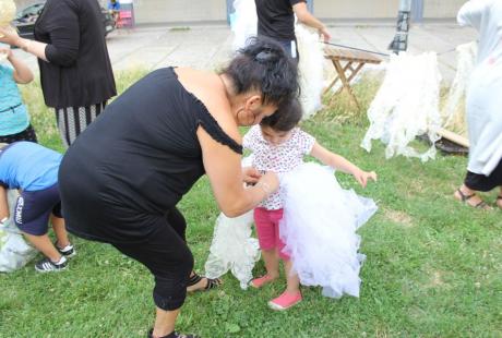 Photo prise à l'occasion de l'événement Carna’light.  Nous voyons une maman accrcocher un tulle blanc autour de sa fille.