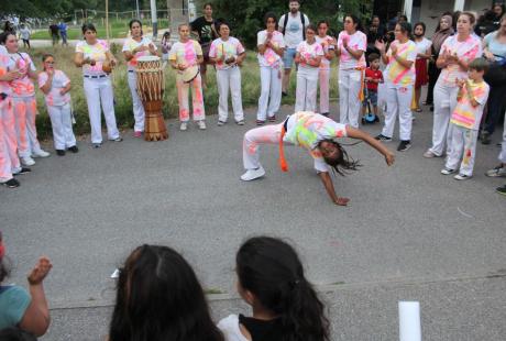 Photo prise à l'occasion de l'événement Carna’light.  Les participants sont habillés de vêtements blanc avec des marques fluorescentes dessus. Ils forment un cercle et au milieu d'eux un artiste fait une démonstration de hip hop