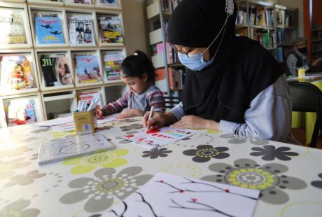 En famille, les participant-es ont joyeusement contribué à alimenter la fresque de dessins à l'image de l'auteur-illustrateur à la bibliothèque La Ponatière.