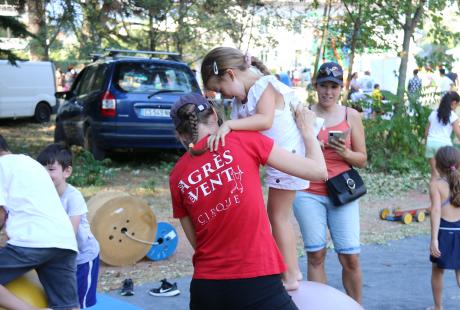 Une intervenante des agrès du Vent aide une fille à traverser en équilibre