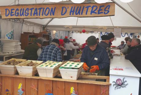 Photo du stand de dégustationd d'huitres, où les bénévoles s'affairent à ouvrir les coquilles 