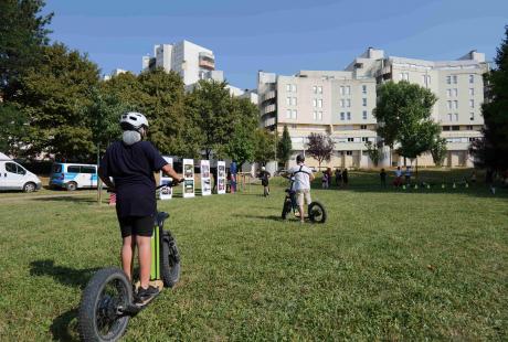 Mi trotinette, mi vélo, pour un tour d'essai dans le parc.