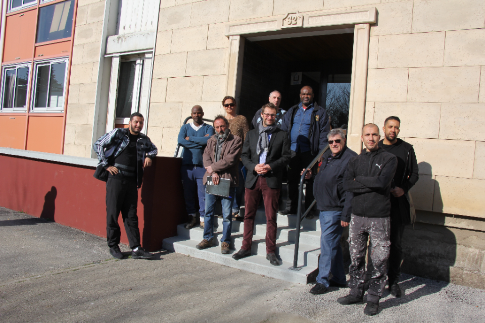 Chantier Luire Propulse SDH Responsables et salariés de la SDH, de Propulse et du service jeunesse de la Ville, devant une entrée d'immeubledevant