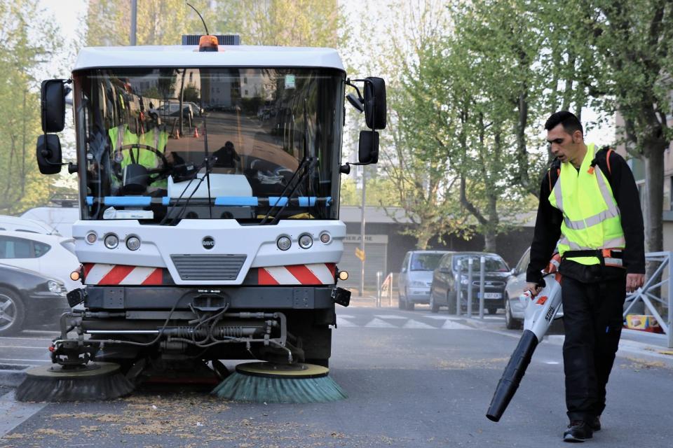 balayeuse et agent nettoient la rue