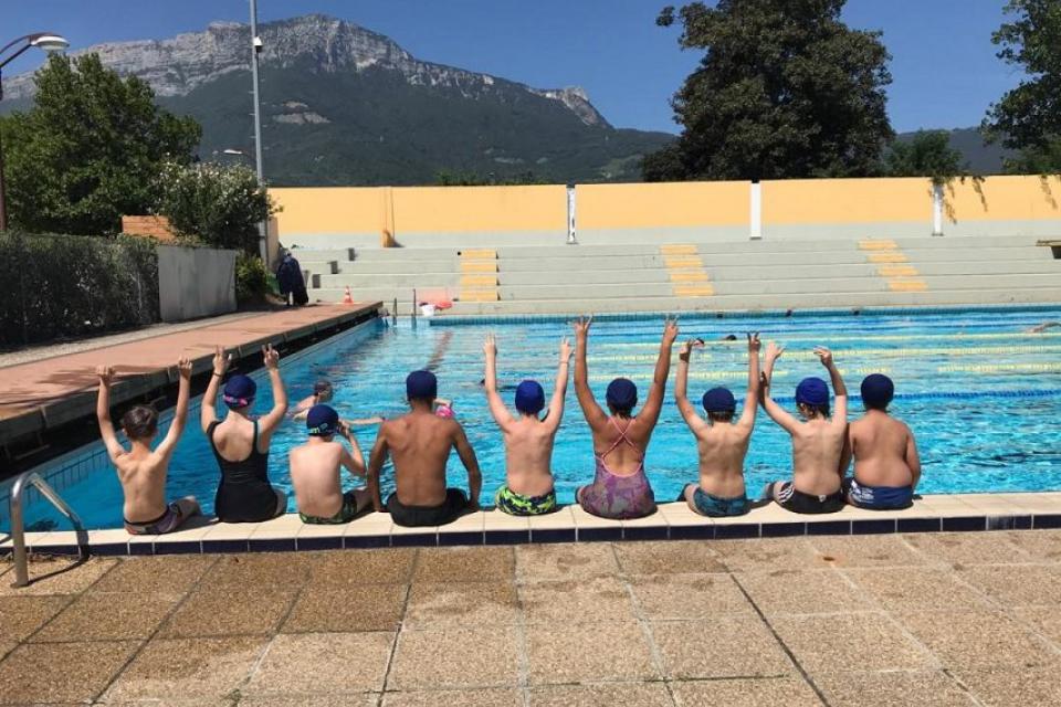 Evade : Des vacances dans le bon tempo ! Plusieurs jeunes sont assis sur le rebord de la piscine.