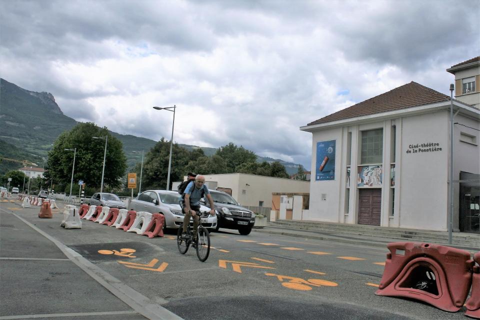 Un cycliste utilise la piste cyclable Tempovelo encore en chantier devant le ciné théâtre de la Ponatière.