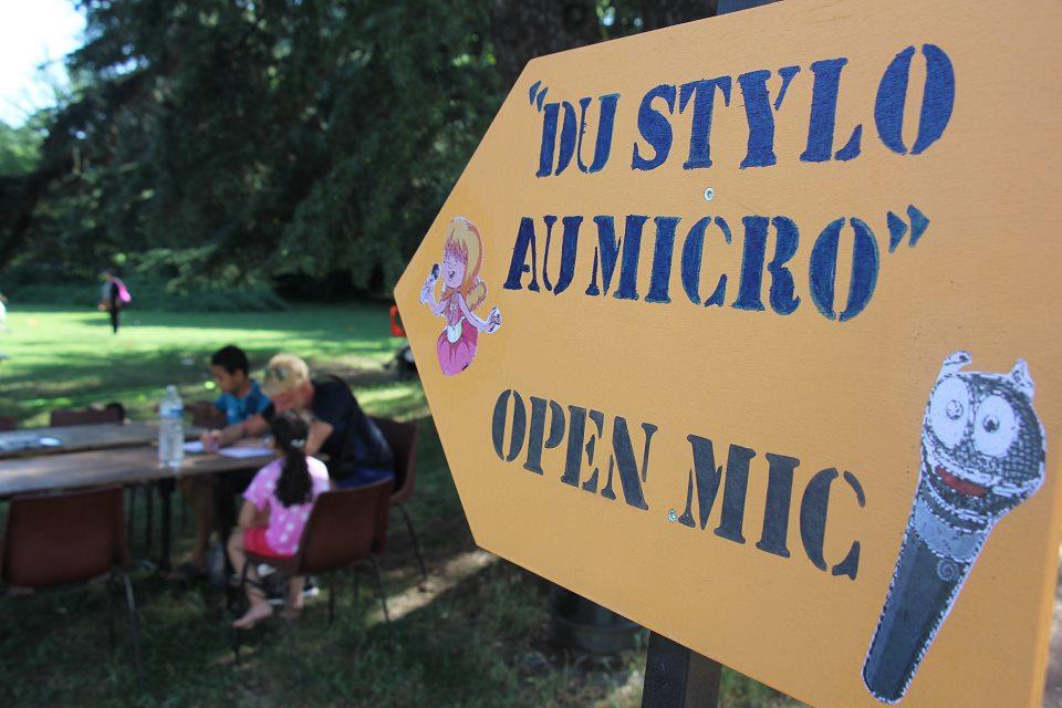 La pancarte "Du stylo au micro" indique la direction pour participer à l'atelier en plein air.