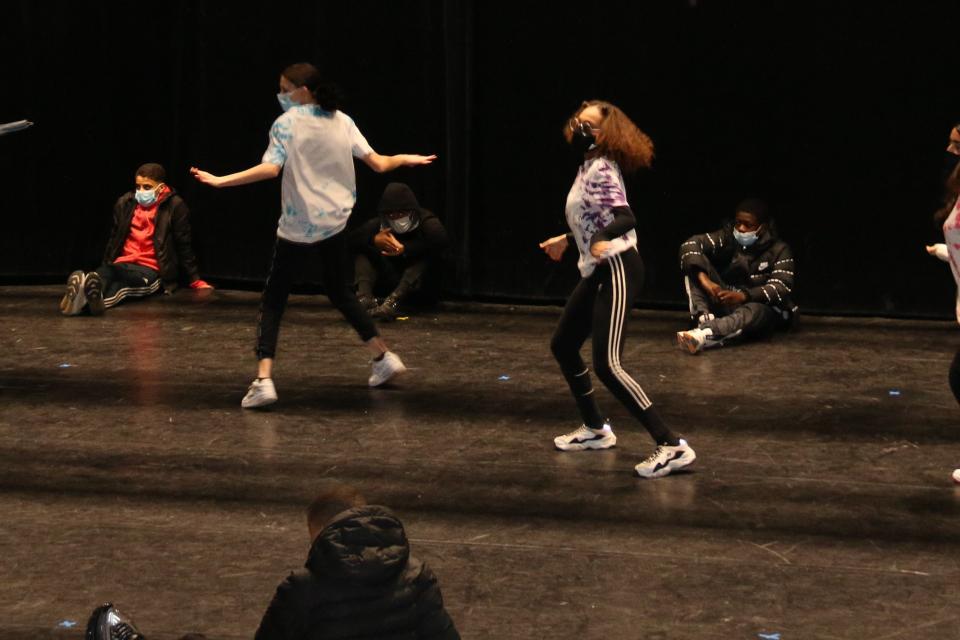 Des jeunes masqués répètent un spectacle de danse sur la scène de la Rampe