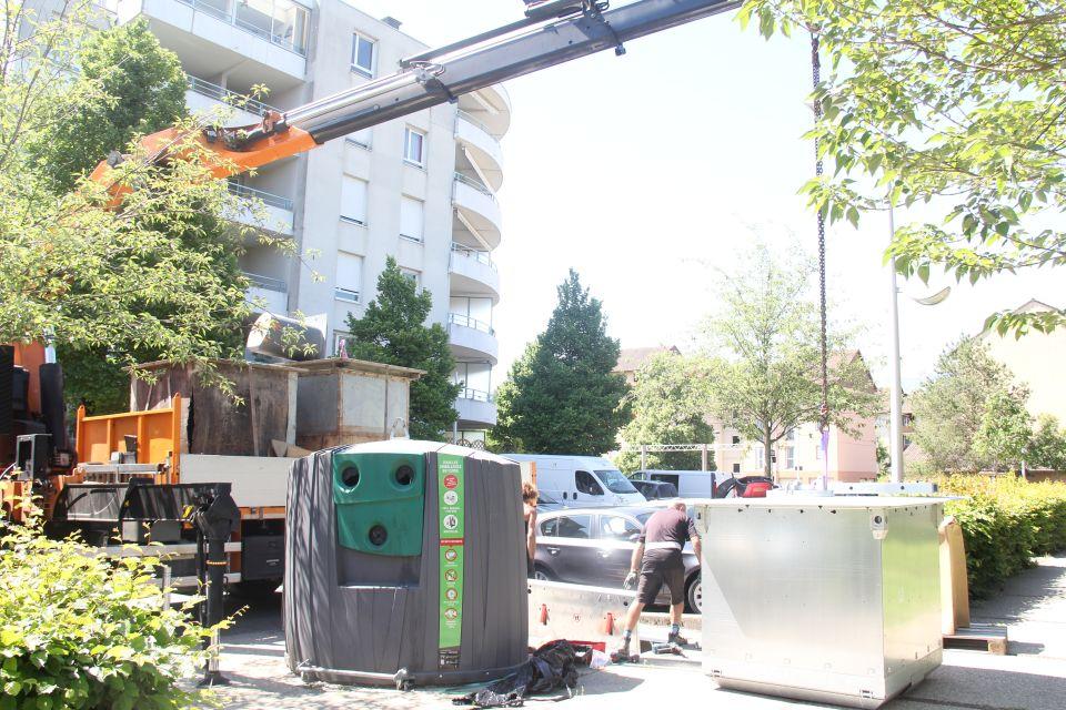 Remplacement de bacs à verre. Photos d'employés en train de changer les bacs à verre de la commune à l'aide d'une grue.