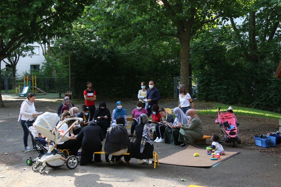 Photo de parents assis sur un banc dans la cour d'une école