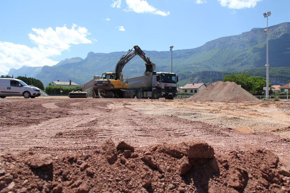 Photo des travaux du stade Delaune. Nous voyons des tas de sable et de gravier et des machines de chantier.