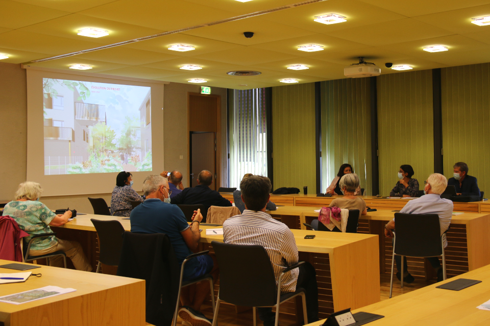 La deuxième réunion de concertation autour du projet d'aménagement du secteur République s'est tenu à l'hôtel de ville. Photo d'une réunion de concertation autour du projet d'aménagement du secteur République qui s'est tenu à l'hôtel de ville. En salle du conseil, les habitant-es et les élu-es sont face à face, un diaporama est projeté sur le mur.