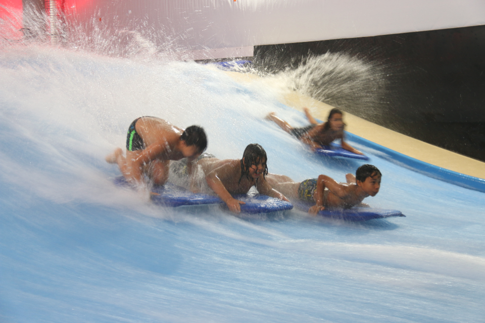 Photo de jeunes surfant sur des vagues artificielles, au complexe La Vague
