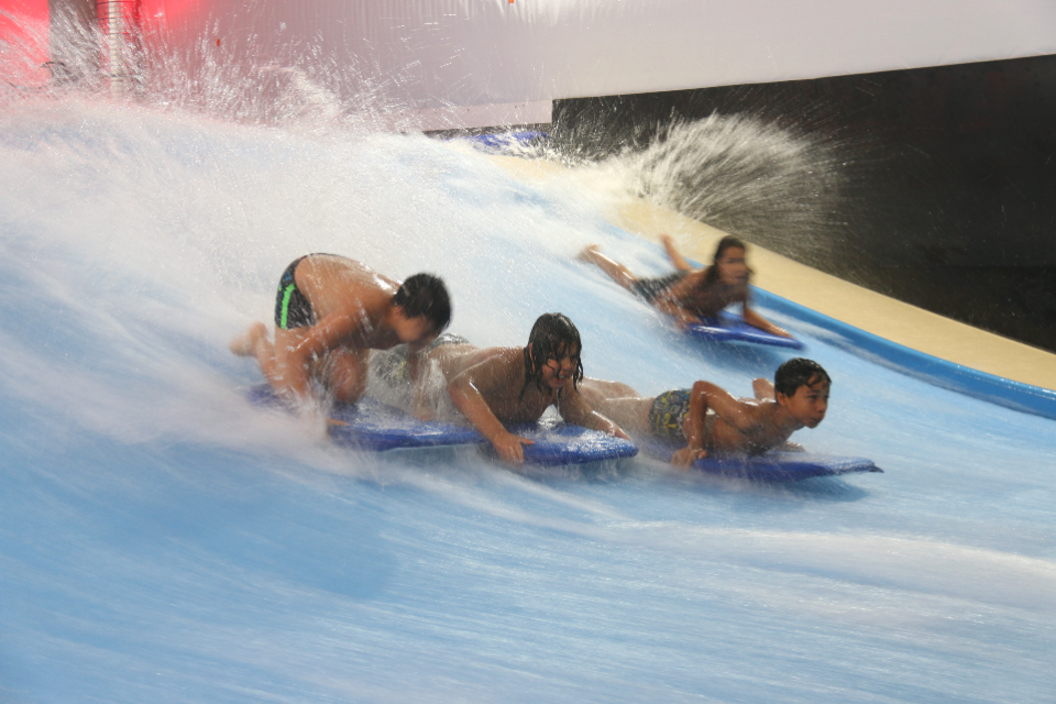 Atout sport surfe sur la vague Photo de jeunes surfant sur des vagues artificielles, au complexe La Vague