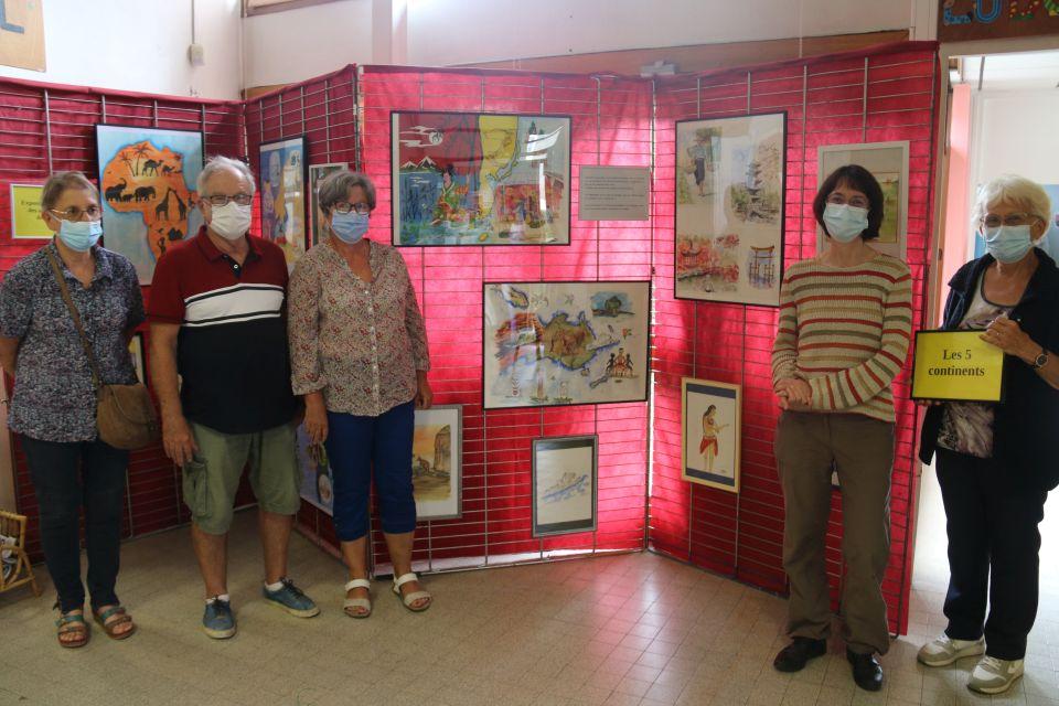 Les membres du groupe d'aquarellistes de la MDH Les Écureuils posent autour de l'exposition hommage à Roger Magguilli, sur le thème des Cinq continents. 
