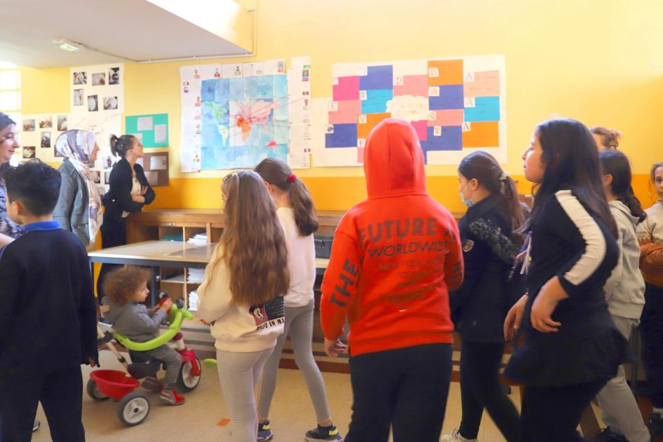 Les enfants de la classe se rassemblent devant leurs productions Les enfants de la classe se rassemblent devant leurs productions