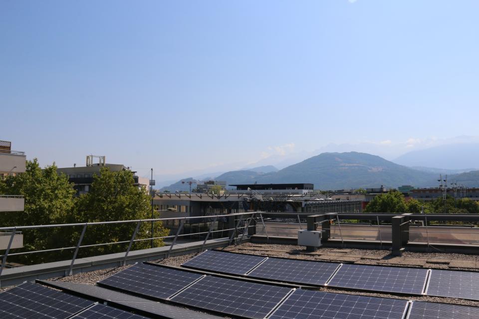 Centrale photovoltaique sur les toits de l'hôtel de ville, en arrière plan le ciel et les montagnes