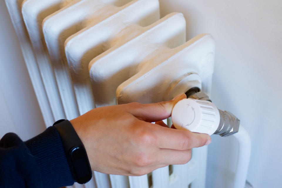 Photo d'une personne ajustant le thermostat de son radiateur