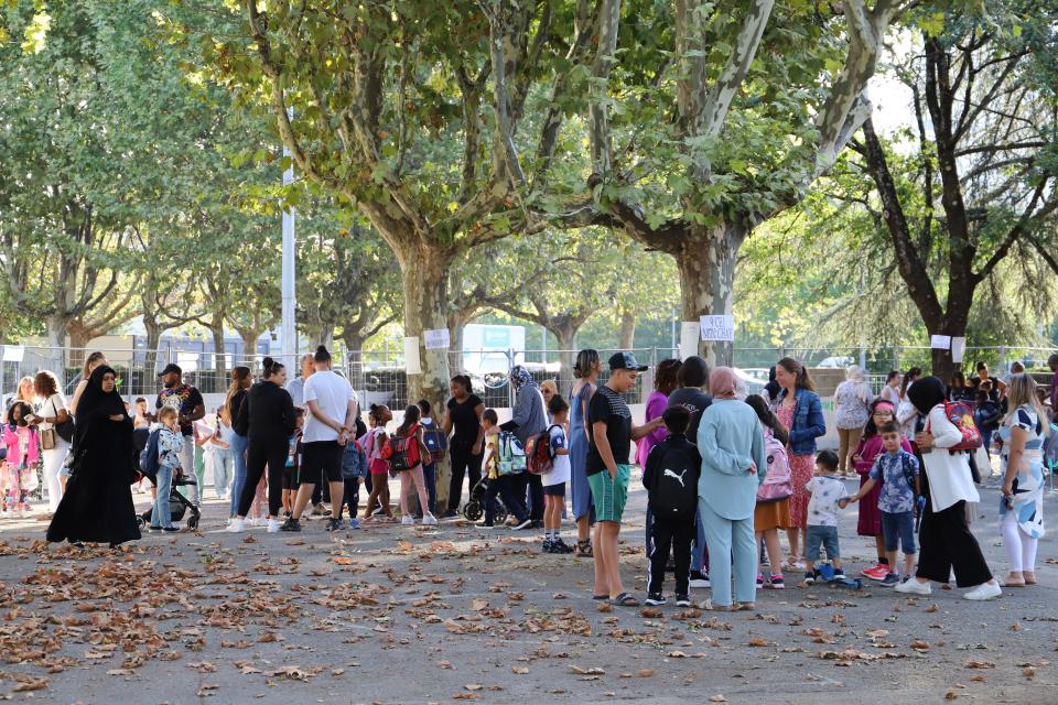 Photo des élèves et des parents dans la cour d'école lors de la rentrée scolaire