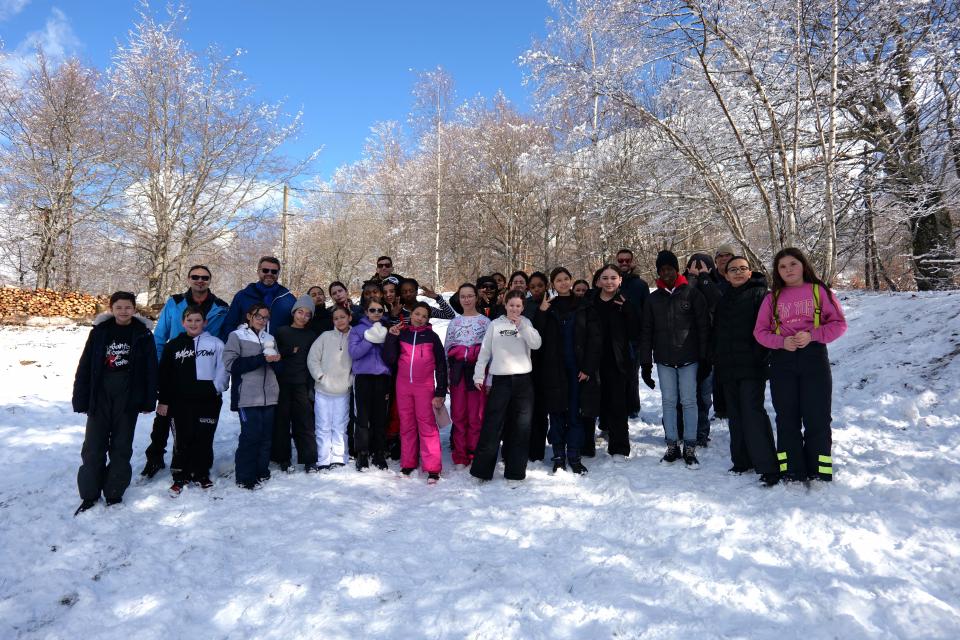 Les 26 élèves du Collège Picasso au col d'Ormon, avec la neige et les montagnes en arrière-plan.