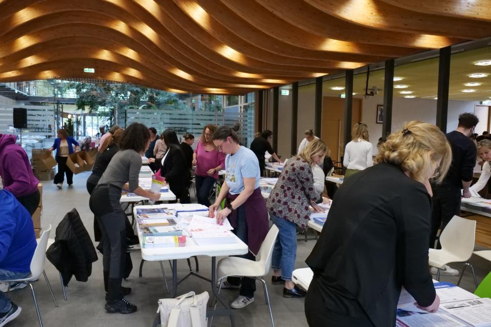 Personnes en train de mettre sous pli les professions de foi des candidats